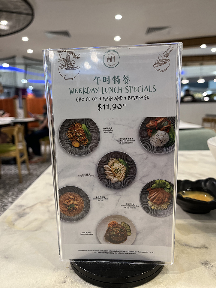 A menu stand displaying Typhoon Cafe's Weekday Lunch Specials with food photos and pricing.