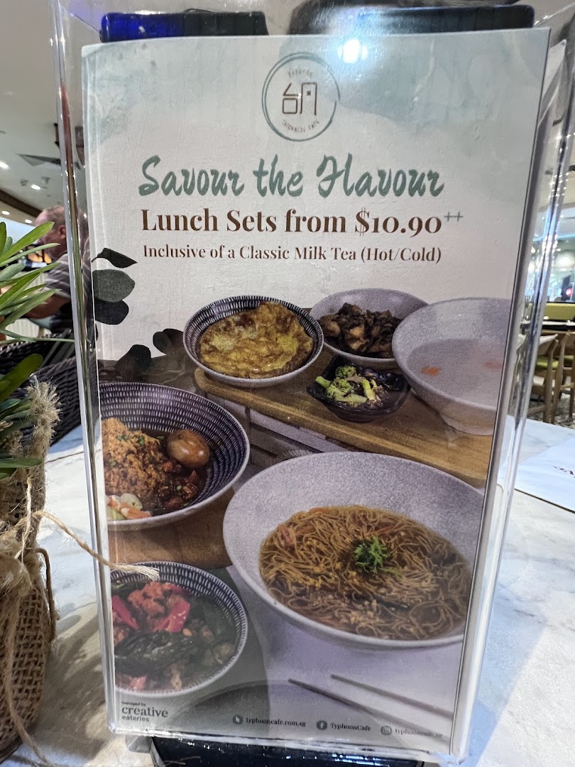 A promotional display showcasing Typhoon Cafe's lunch sets with various dishes and a milk tea offer.