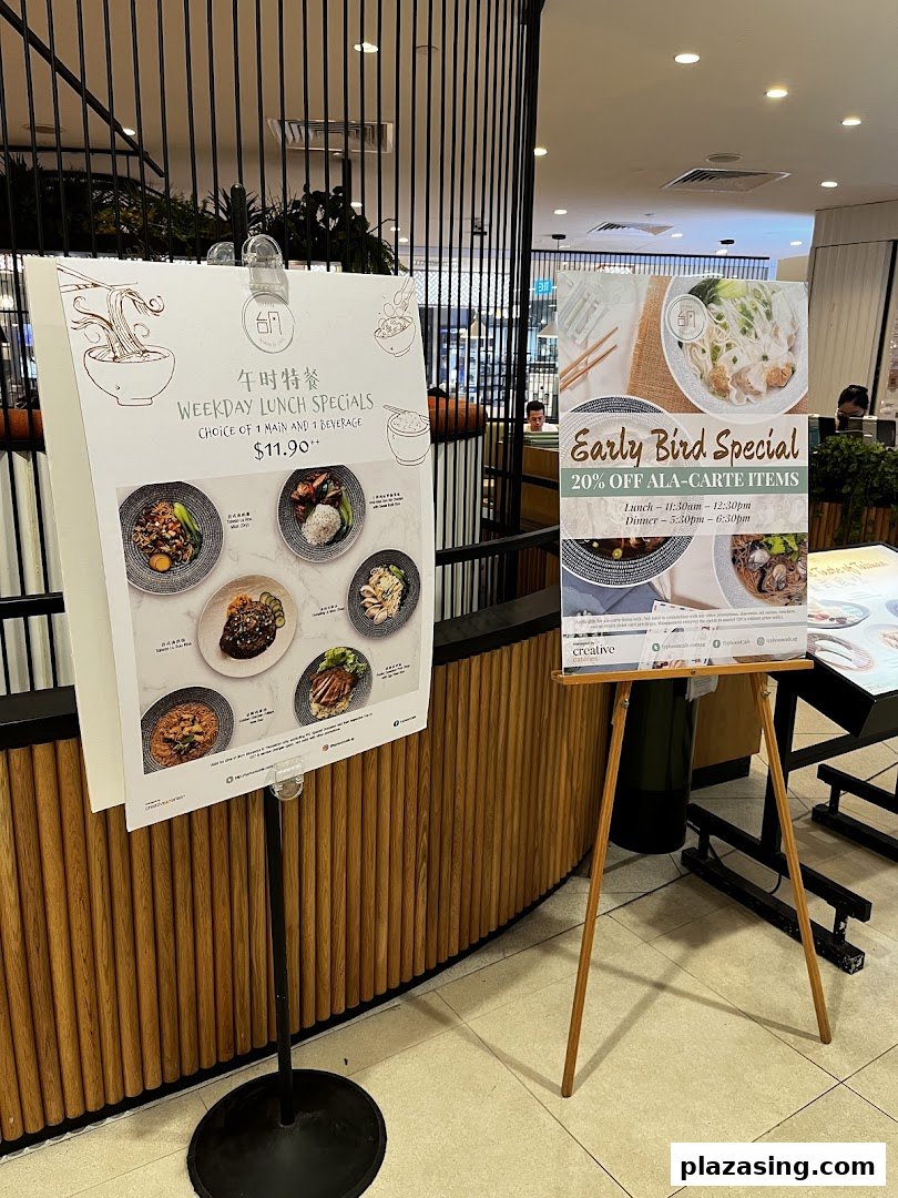 Two promotional stands outside Typhoon Cafe, showcasing weekday lunch specials and an early bird discount.