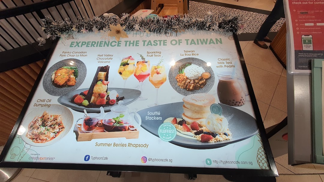 A promotional menu board showcasing various Taiwanese dishes and drinks from Typhoon Cafe.