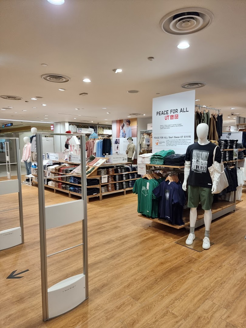 Interior view of UNIQLO, showcasing clothing displays, mannequins, and the store's spacious layout.