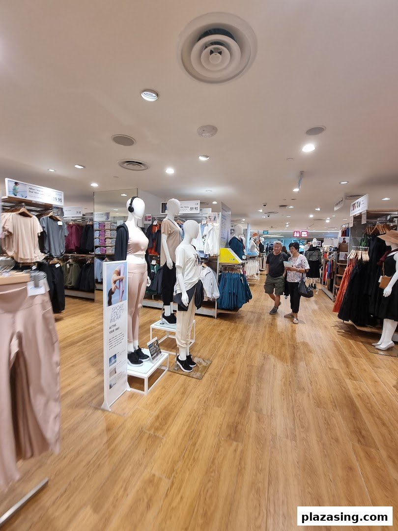 Inside UNIQLO, showcasing a wide range of apparel on mannequins and racks, with customers browsing.