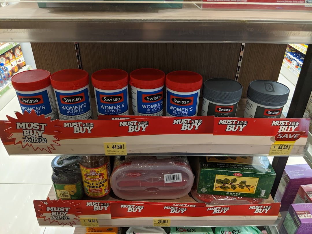 Shelves displaying health supplements, organic products, and tea with 'Must Buy' promotions at Unity Plaza Singapura.