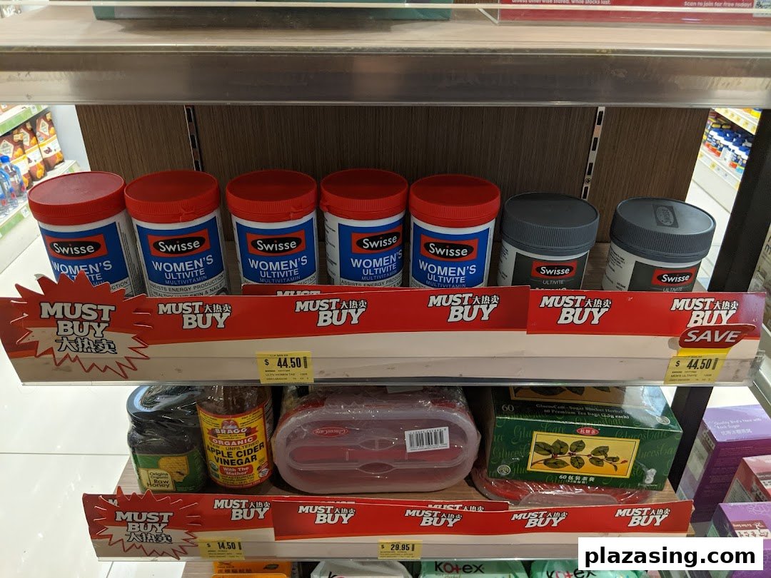Shelves displaying health supplements, organic products, and tea with 'Must Buy' promotions at Unity Plaza Singapura.