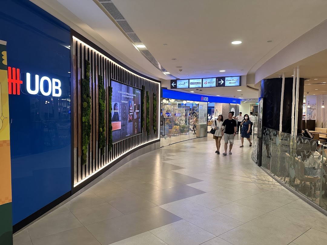 The UOB bank branch entrance with a large digital display and green wall in a shopping mall.