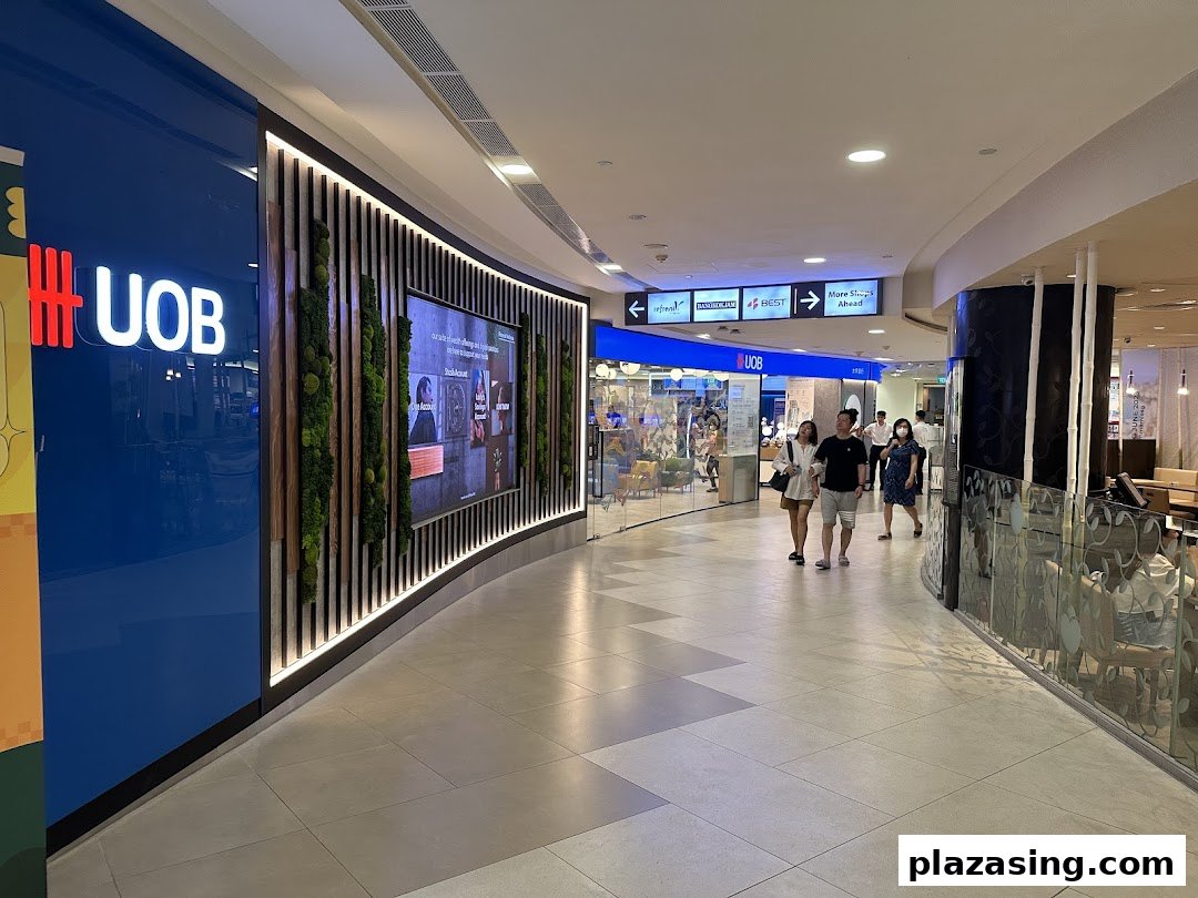 The UOB bank branch entrance with a large digital display and green wall in a shopping mall.