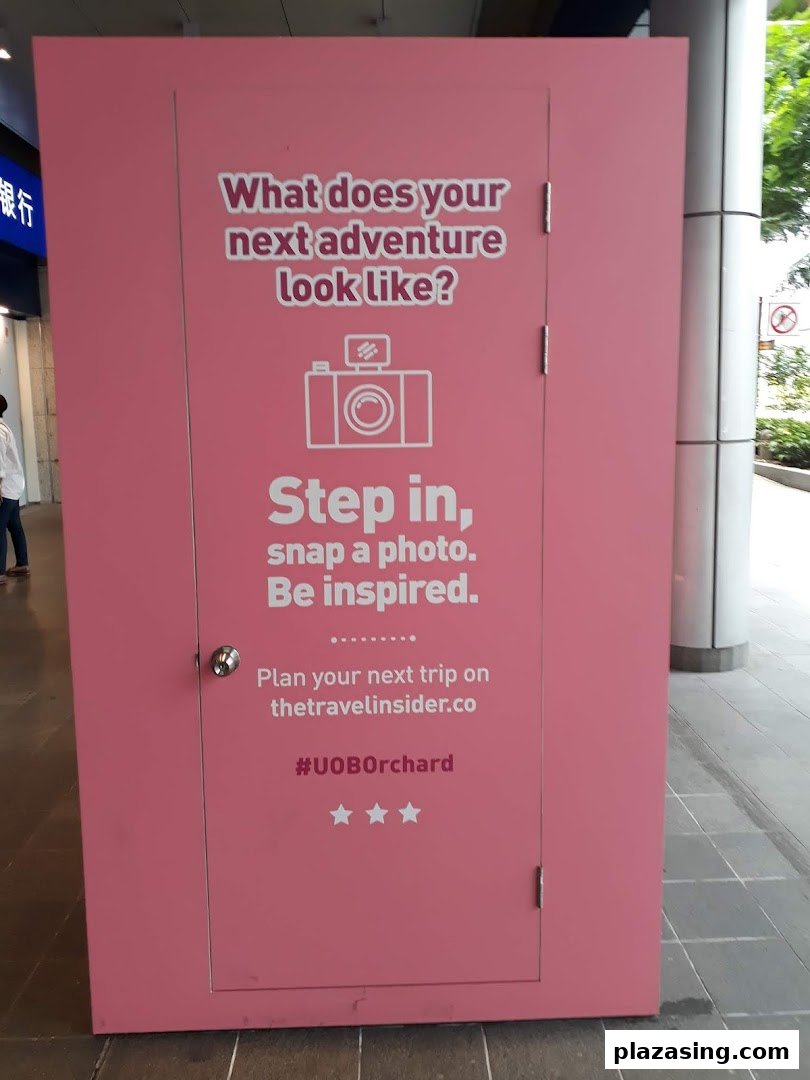 A pink interactive display inviting visitors to imagine their next adventure and snap a photo.