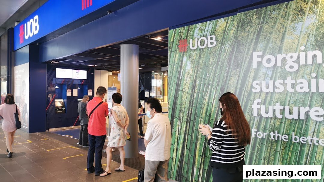 The UOB Orchard Branch entrance with customers queuing, showcasing the bank's prominent blue signage and green bamboo-themed branding.