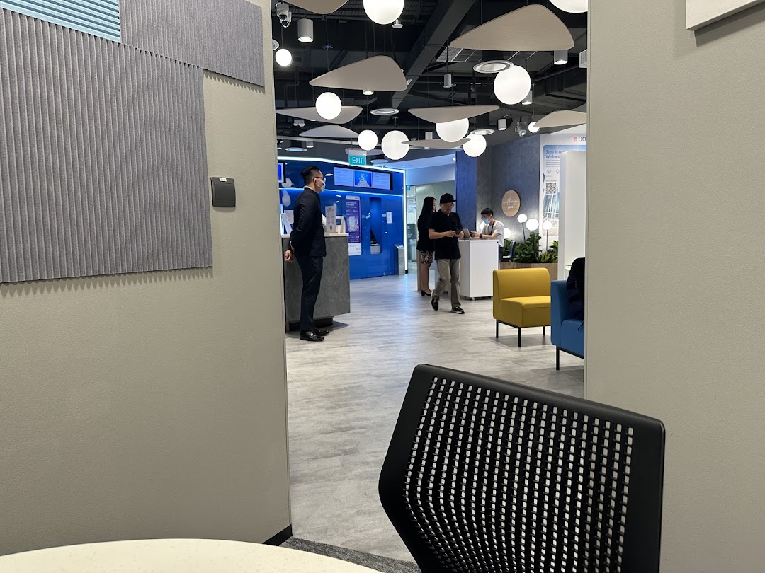 A modern UOB bank branch interior with staff assisting customers and comfortable seating areas.