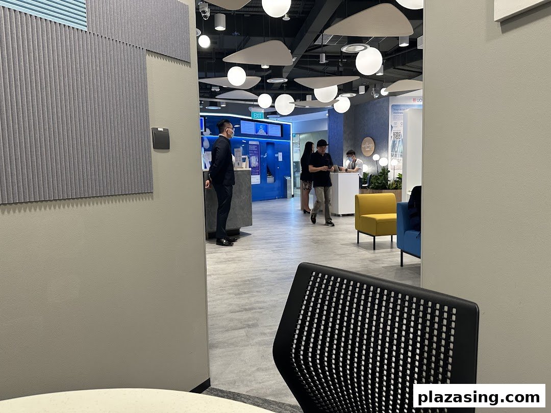 A modern UOB bank branch interior with staff assisting customers and comfortable seating areas.
