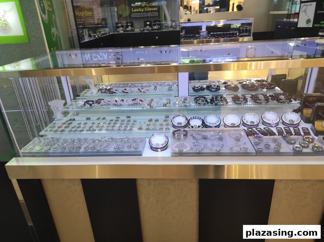 A brightly lit display case showcasing a wide array of necklaces, bracelets, and charms.