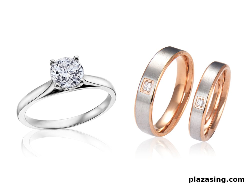 A close-up of a diamond solitaire engagement ring and a pair of two-tone wedding bands.