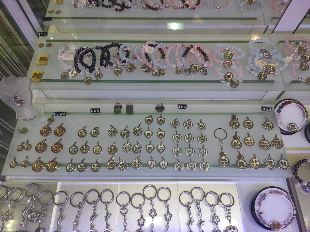 A display cabinet showcasing various four-leaf clover themed jewelry, pendants, and keychains.