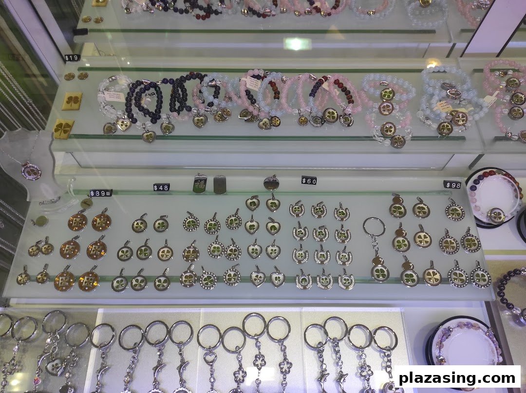 A display cabinet showcasing various four-leaf clover themed jewelry, pendants, and keychains.