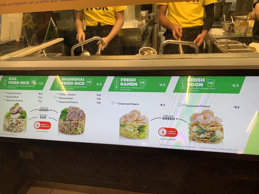 Wok Hey's digital menu board showcasing fried rice, ramen, and udon dishes with prices, and chefs at work.