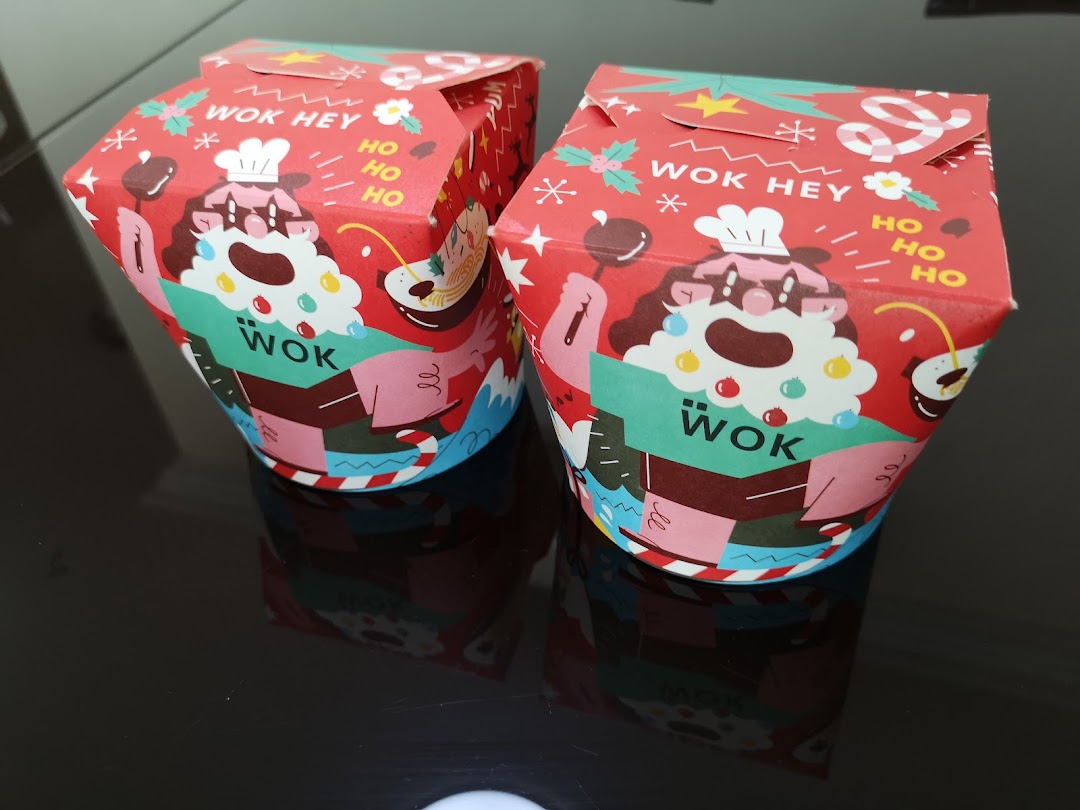 Two festive-themed WOK HEY takeaway boxes featuring a Santa-like chef design.