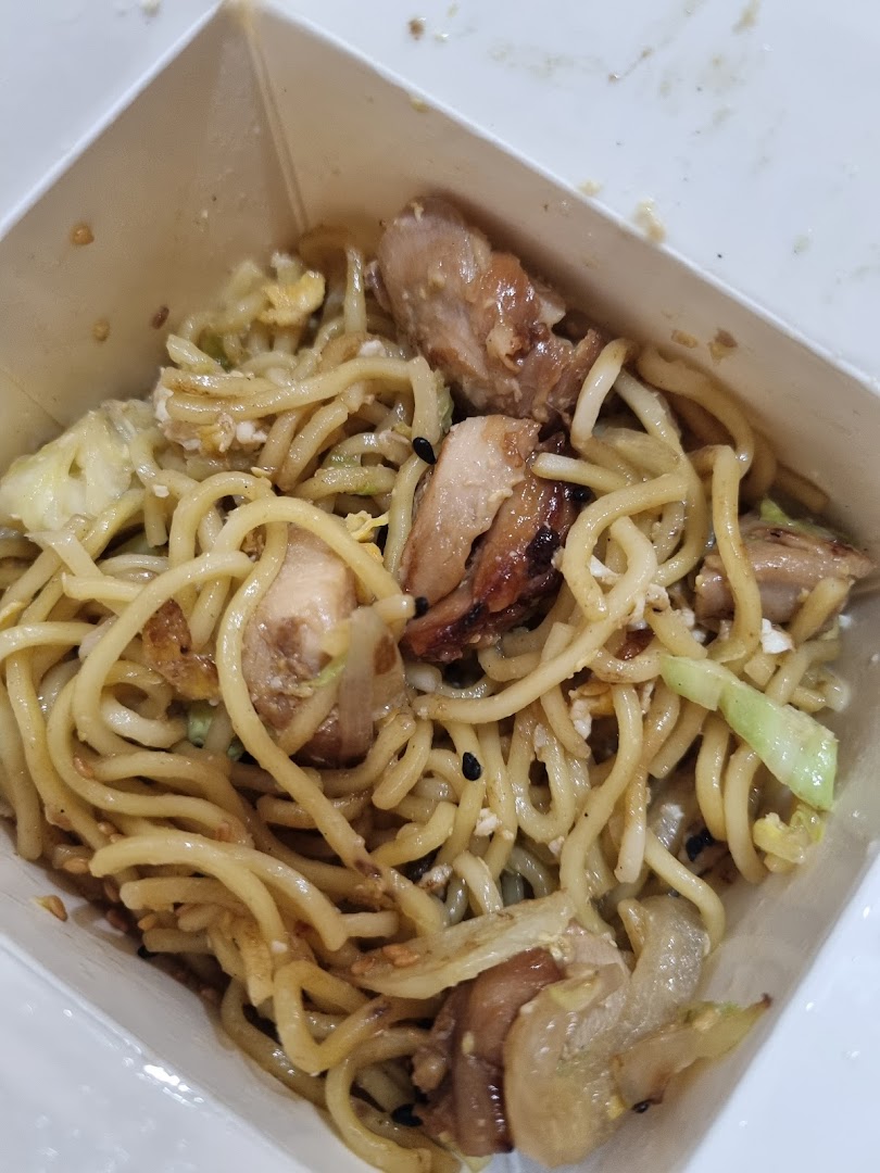 A close-up of delicious stir-fried noodles with chicken and vegetables in a Wok Hey takeaway box.