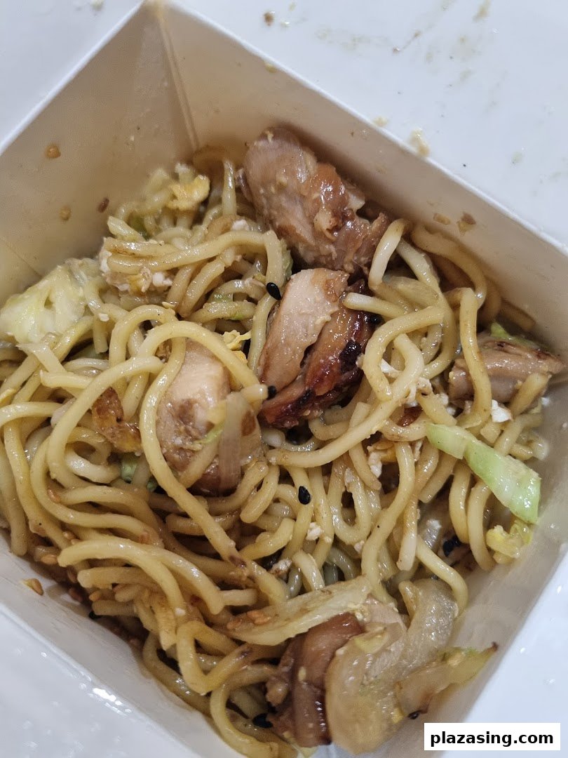 A close-up of delicious stir-fried noodles with chicken and vegetables in a Wok Hey takeaway box.