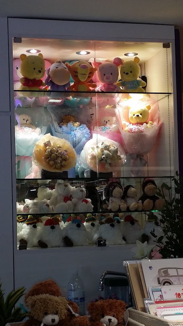 A display cabinet showcasing various plush toy bouquets, chocolate bouquets, and teddy bears.