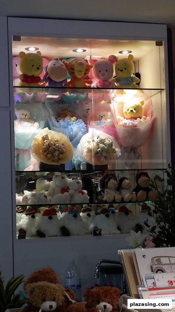 A display cabinet showcasing various plush toy bouquets, chocolate bouquets, and teddy bears.
