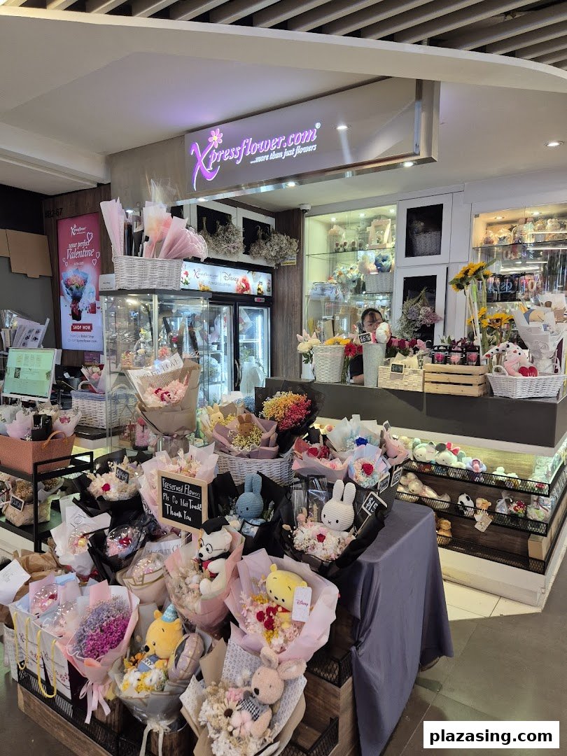 An interior view of Xpressflower, showcasing various floral arrangements, preserved flowers, and plush toy bouquets.