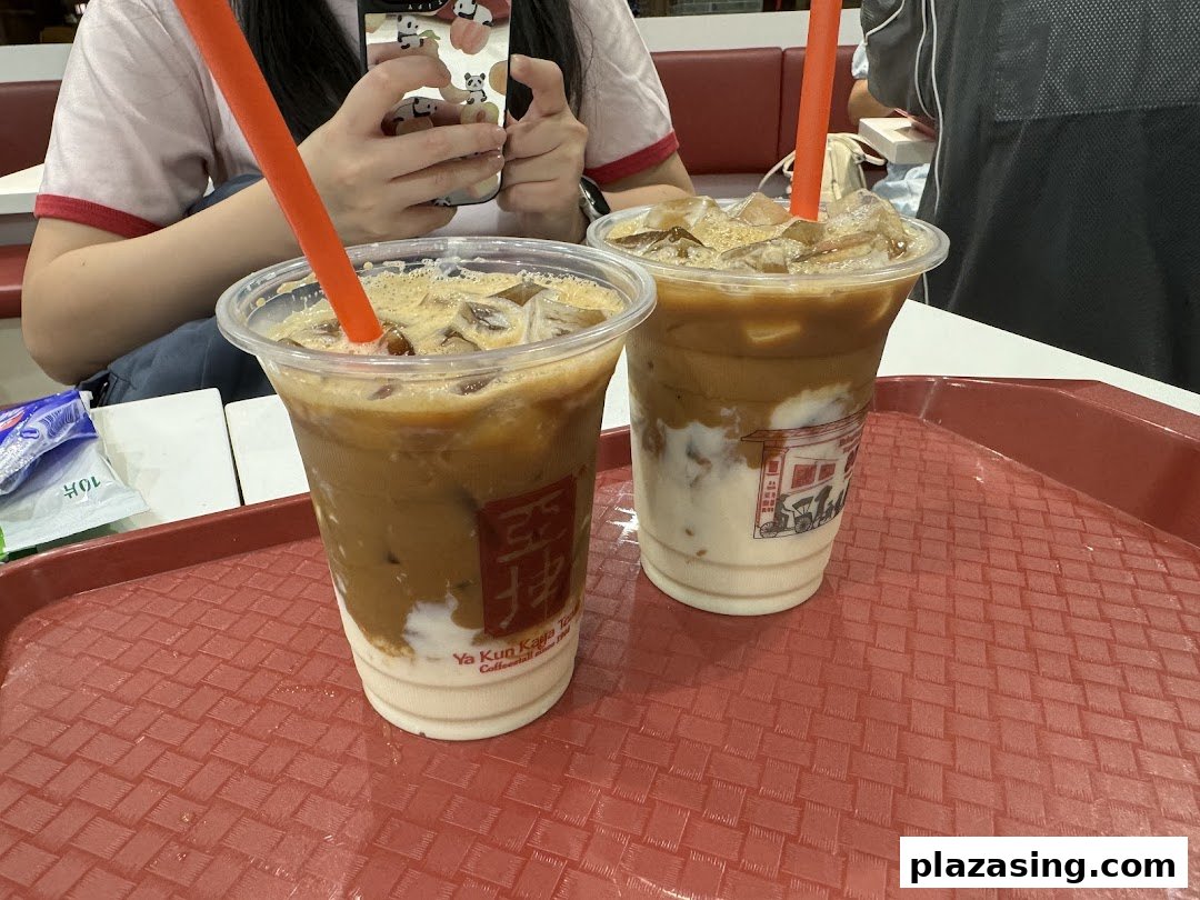 Two refreshing iced coffee drinks from Ya Kun Kaya Toast on a red tray, ready to be enjoyed.
