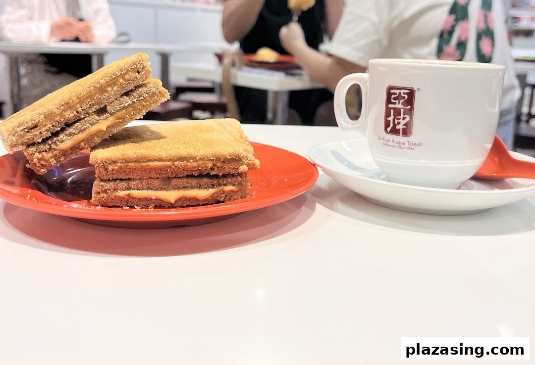 A close-up of traditional kaya toast and a cup of coffee on a white table at Ya Kun Kaya Toast.