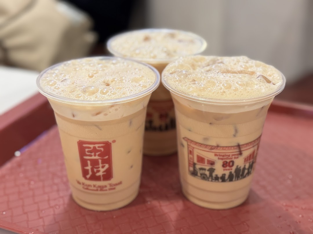Three refreshing iced beverages with foam, branded 'Ya Kun Kaya Toast', served on a red tray.