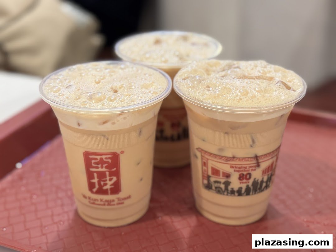 Three refreshing iced beverages with foam, branded 'Ya Kun Kaya Toast', served on a red tray.