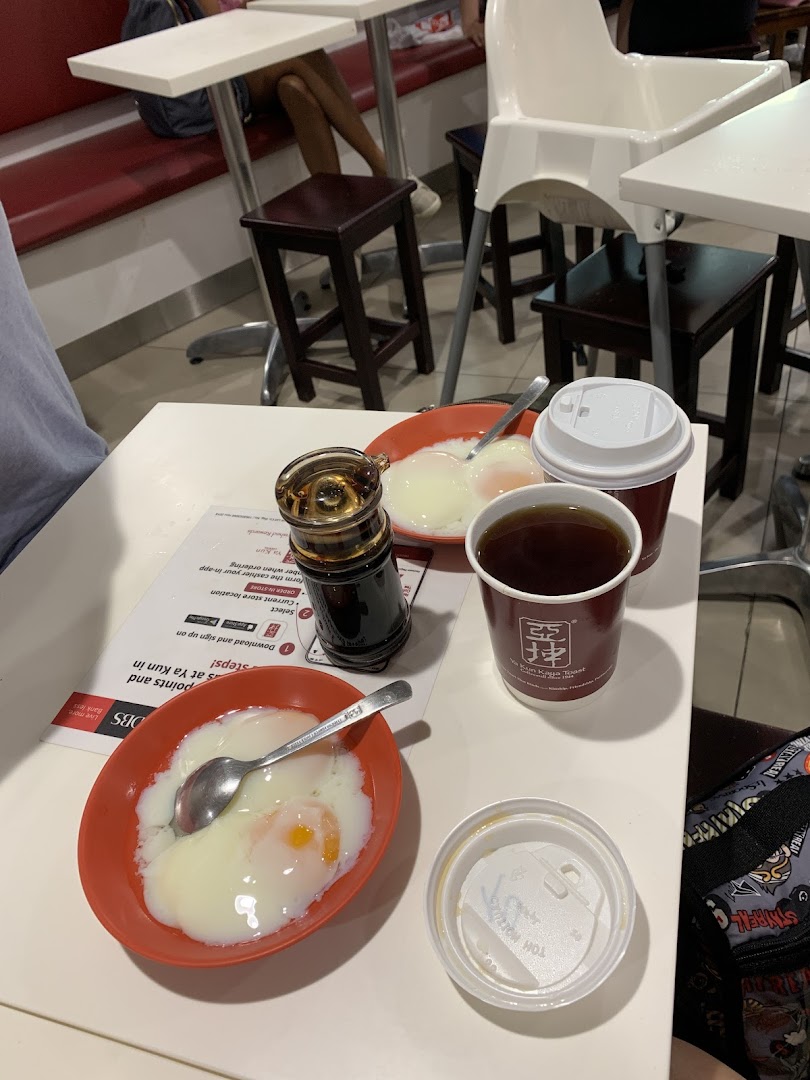 A table at Ya Kun Kaya Toast featuring traditional soft-boiled eggs, coffee, and tea, ready for a classic breakfast.