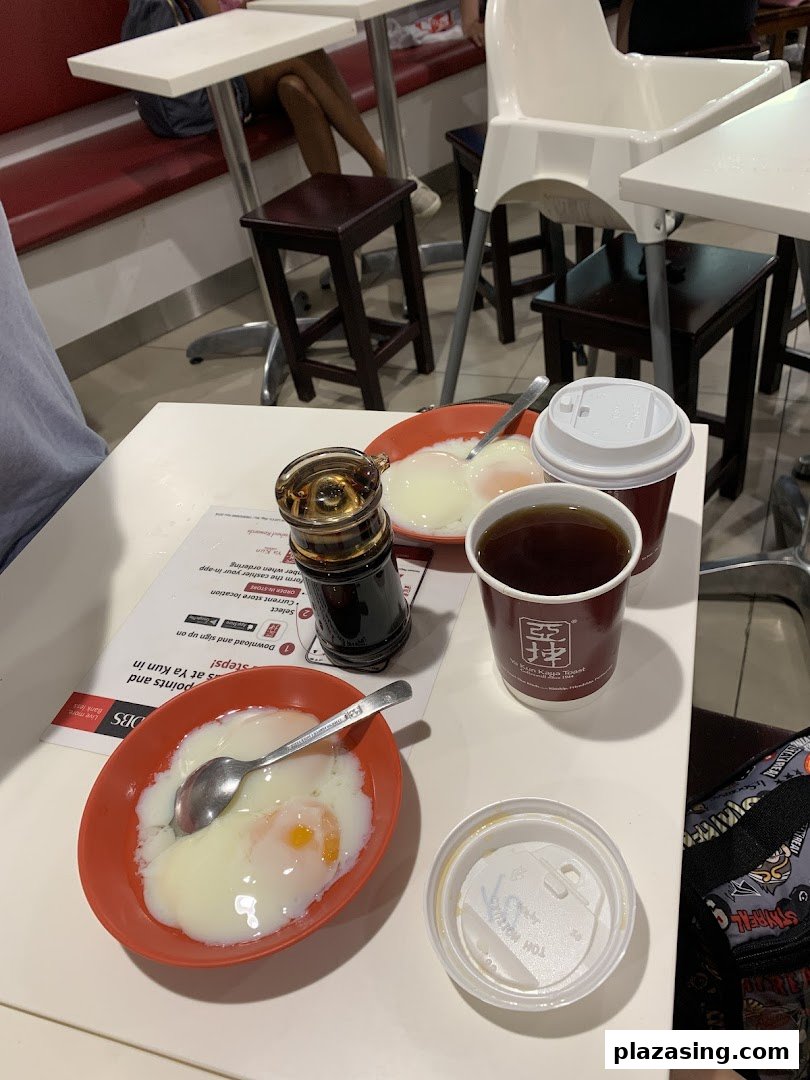 A table at Ya Kun Kaya Toast featuring traditional soft-boiled eggs, coffee, and tea, ready for a classic breakfast.