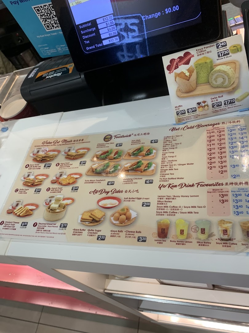 A detailed menu board showcasing various toast sets, sides, and beverages at Ya Kun Kaya Toast.