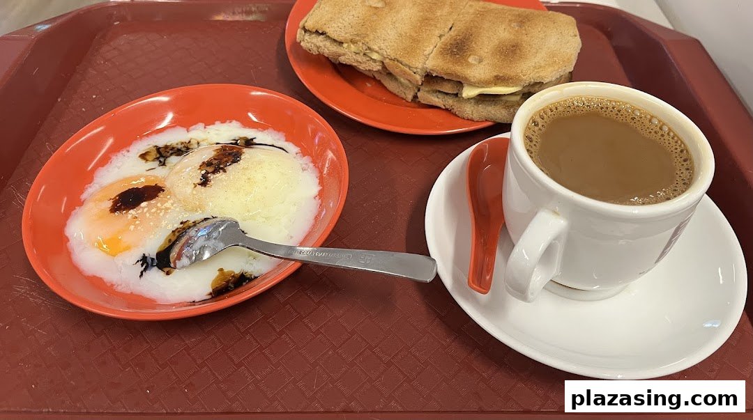 A classic Singaporean breakfast set featuring soft-boiled eggs, kaya toast, and a cup of coffee.