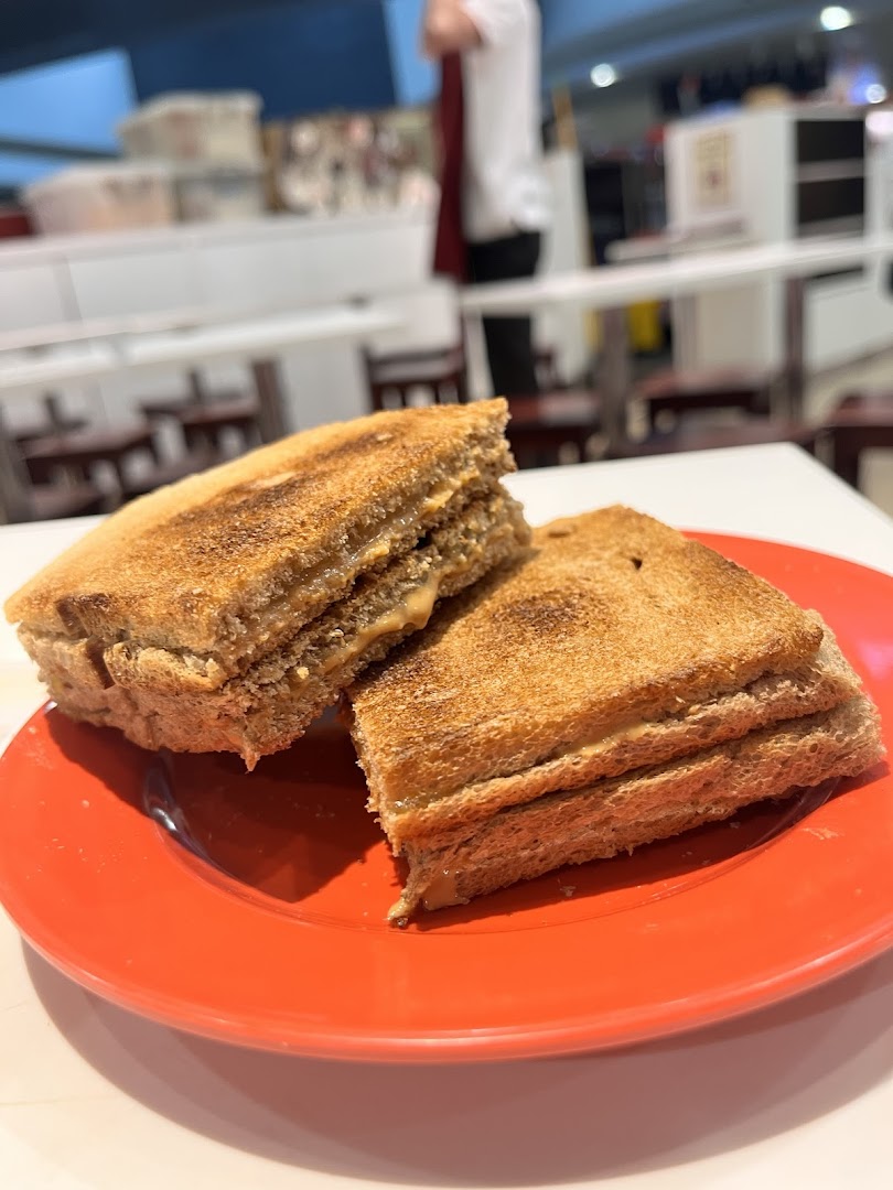 Close-up of two pieces of golden-brown toast with a creamy filling on a vibrant red plate.