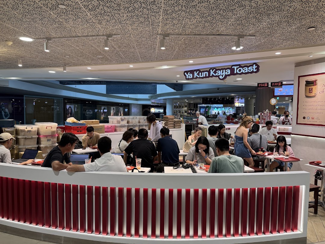 Customers enjoy traditional kaya toast and coffee in the bustling interior of Ya Kun Kaya Toast.