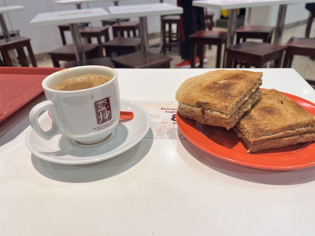 A classic set of kaya toast and a cup of traditional kopi/teh on a table at Ya Kun Kaya Toast.
