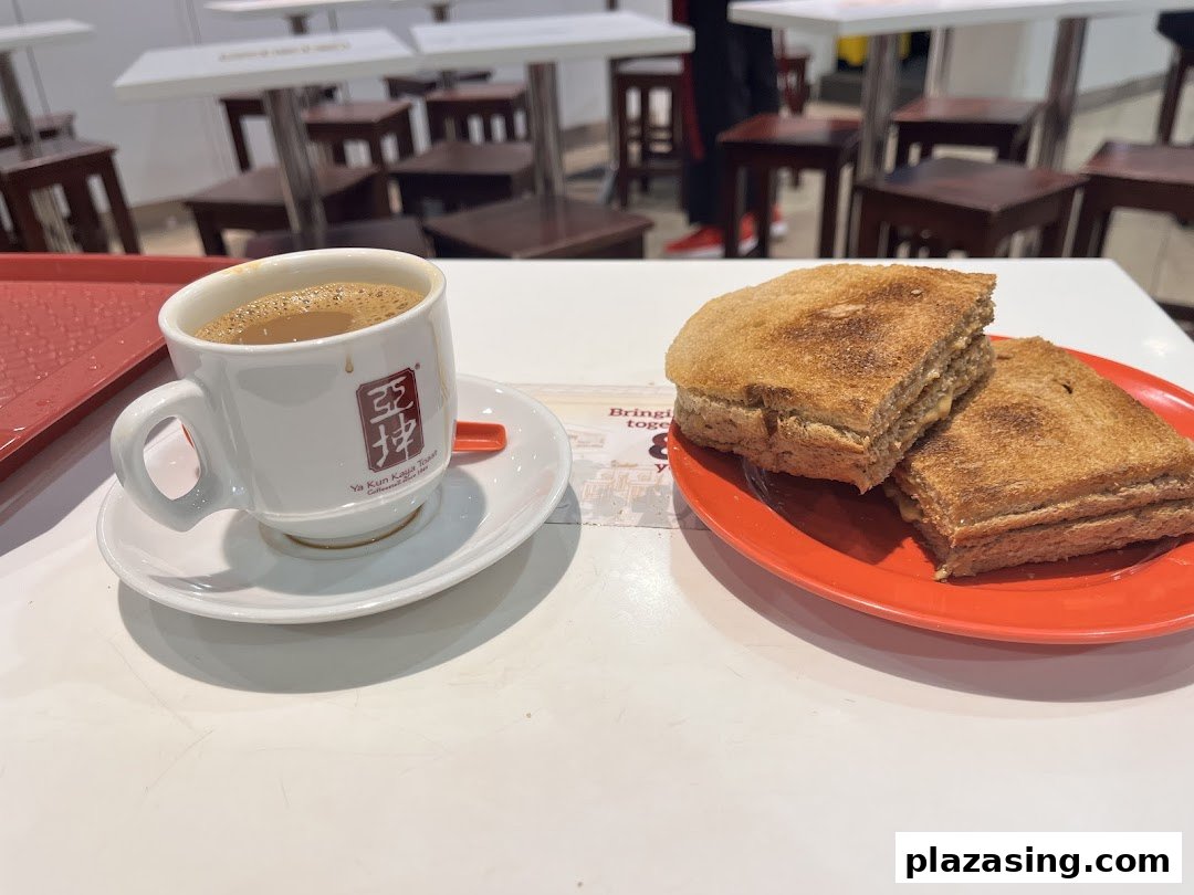 A classic set of kaya toast and a cup of traditional kopi/teh on a table at Ya Kun Kaya Toast.