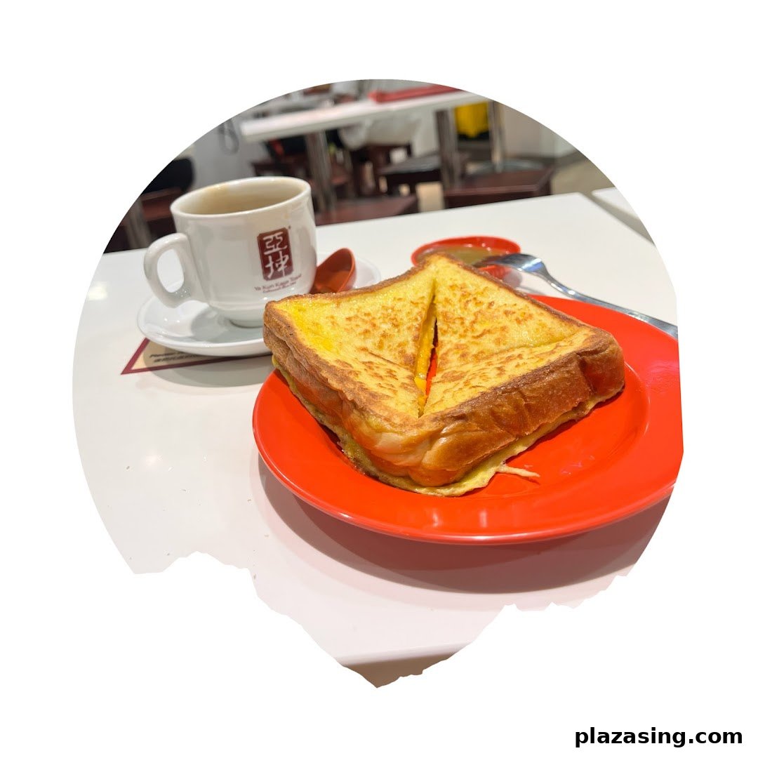 A plate of golden French toast and a cup of coffee on a white table at Ya Kun Kaya Toast.