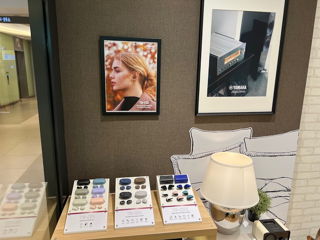 An interior shot of Yamaha AV Experience Studio showcasing wireless earbuds and audio equipment displays.