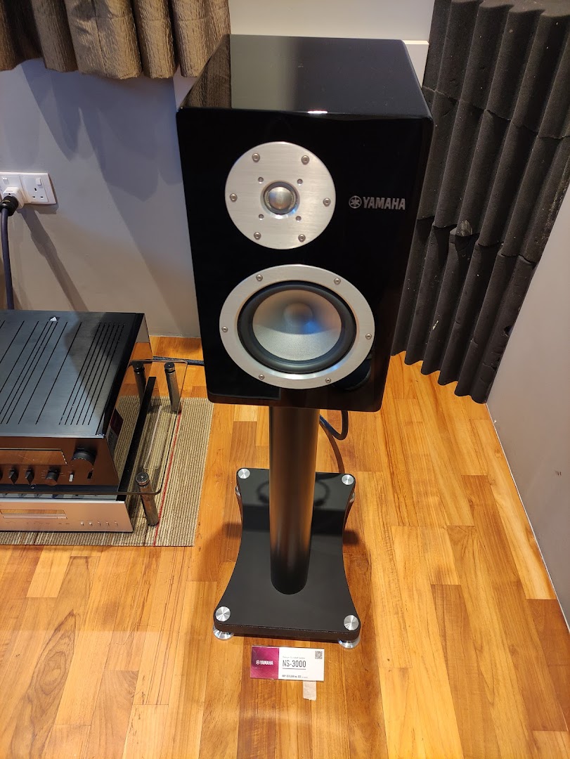 A sleek black Yamaha NS-3000 speaker on a stand, showcasing premium audio equipment.