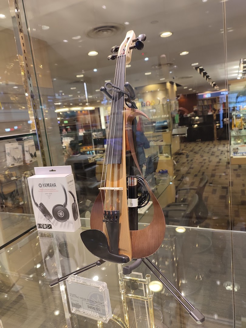 A modern Yamaha electric violin and headphones are showcased in a retail display.