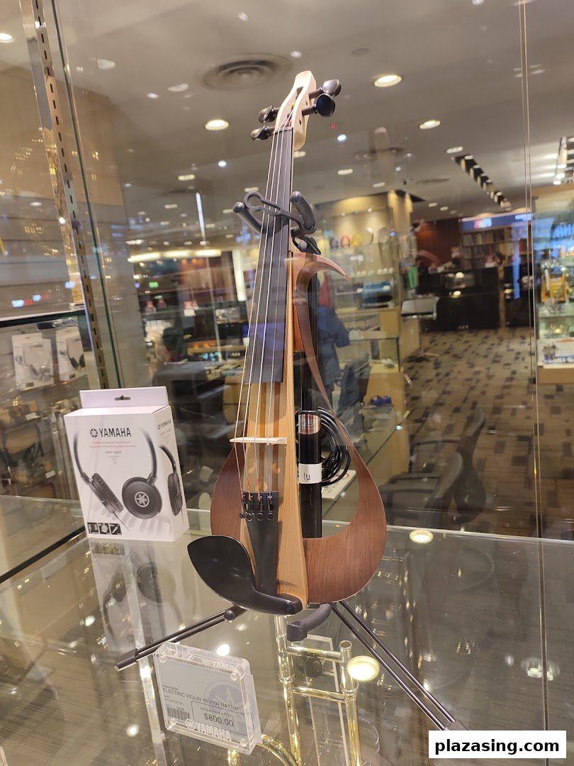 A modern Yamaha electric violin and headphones are showcased in a retail display.