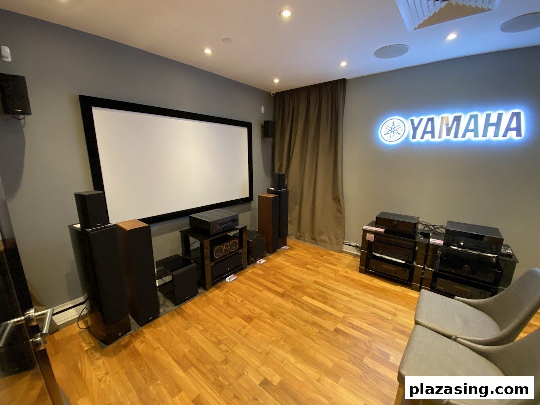 An immersive home theater demo room featuring Yamaha audio-visual equipment and a large projection screen.