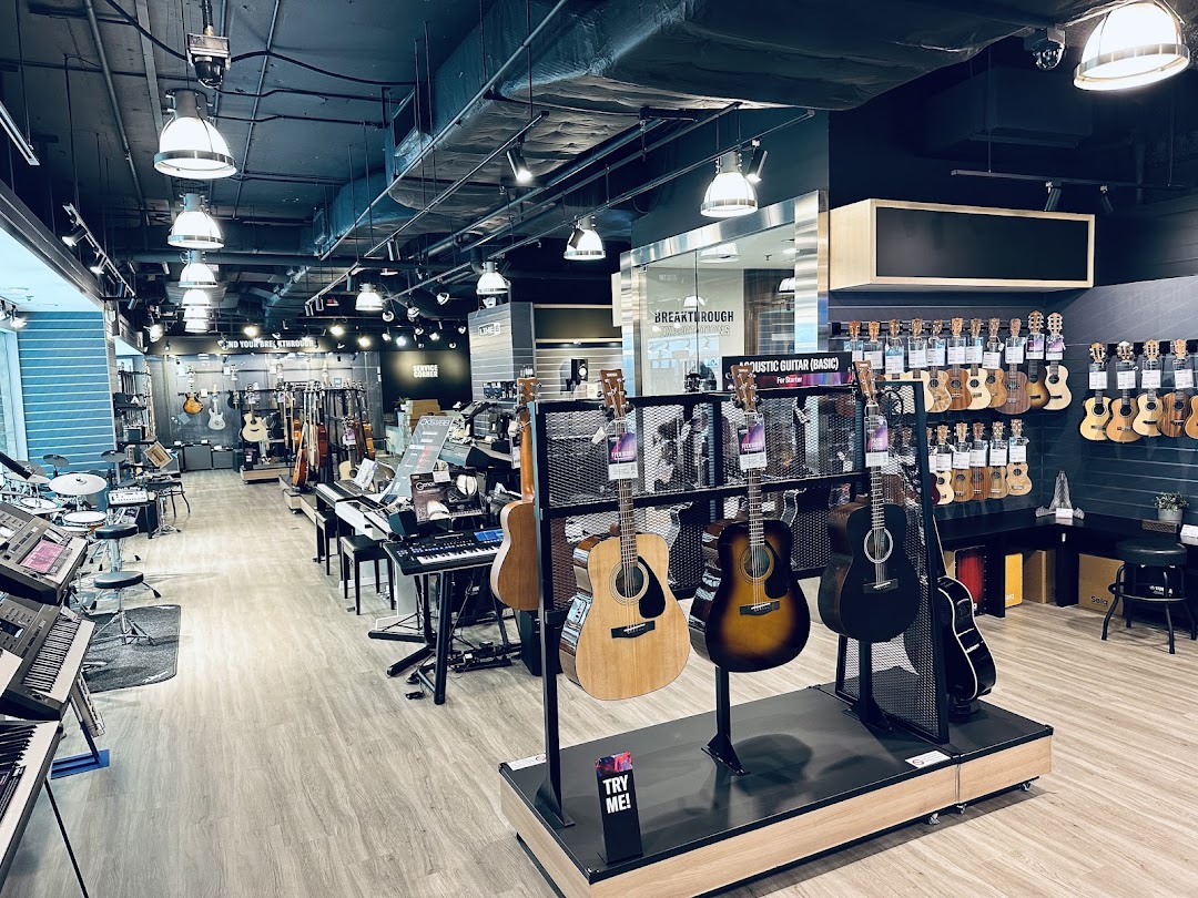 An interior view of Yamaha Music Store, showcasing a wide selection of guitars, ukuleles, keyboards, and drums.