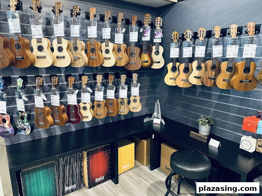 A vibrant display of ukuleles and guitars on a slat wall, showcasing various models and sizes in a music store.