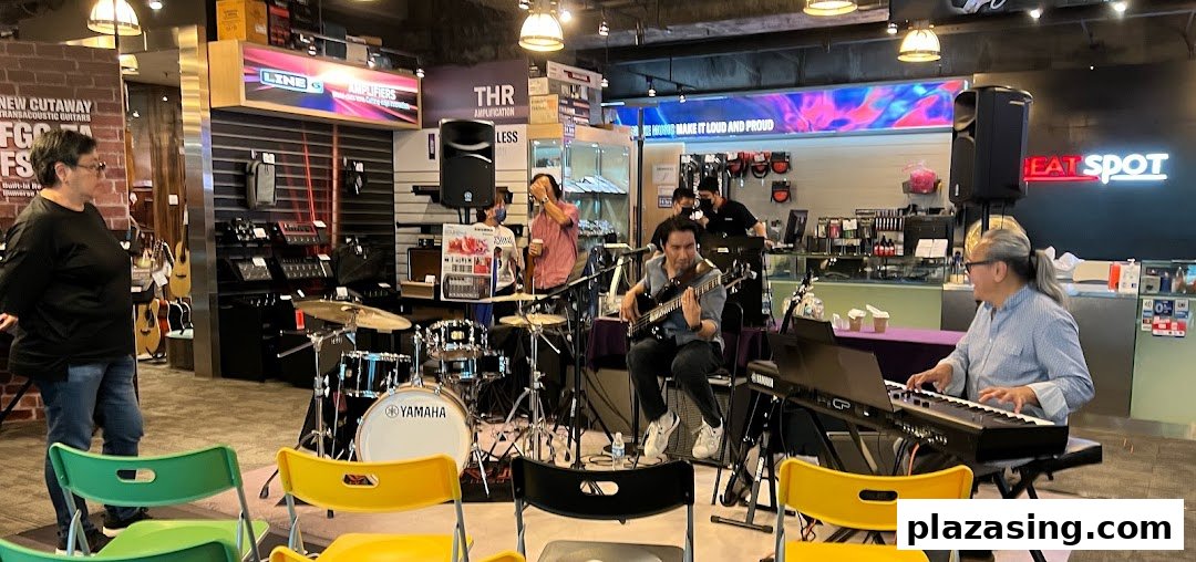 A live band performs inside the Yamaha Music Store, surrounded by musical instruments and equipment.
