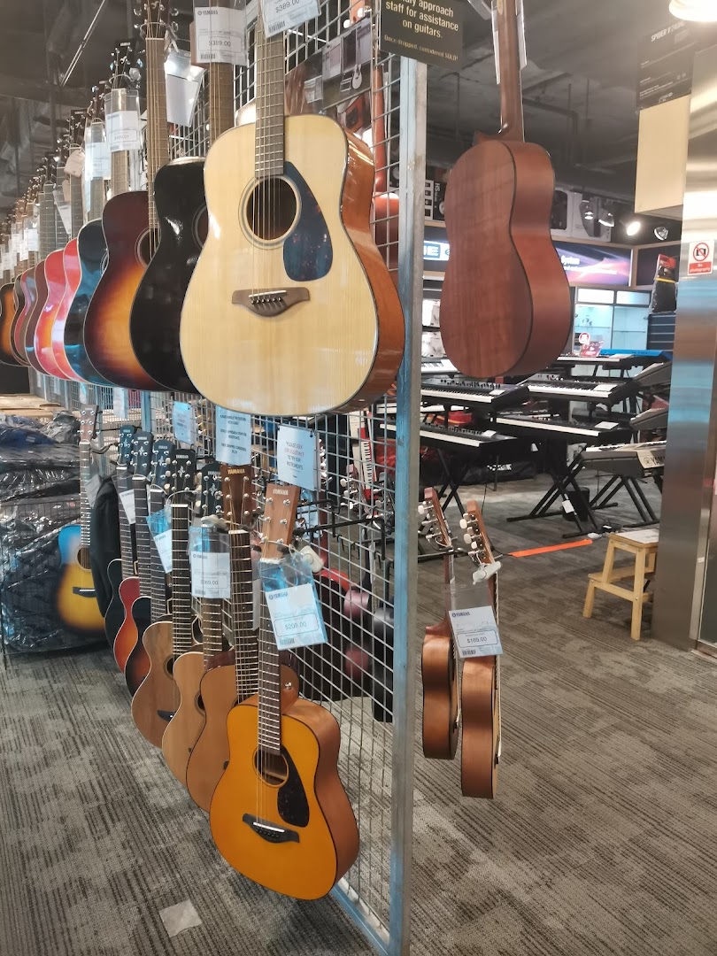 A vibrant display of acoustic guitars and keyboards inside the Yamaha Music Store.