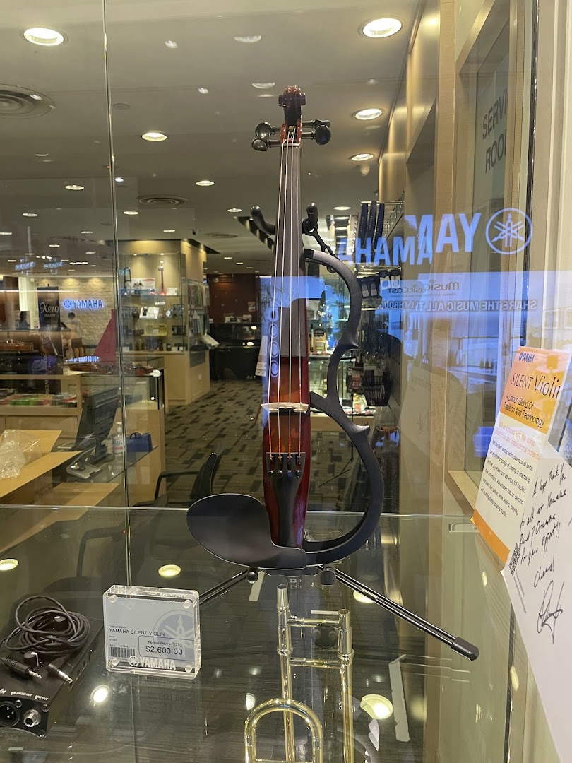 A Yamaha Silent Violin is prominently displayed in a glass showcase at the music store.