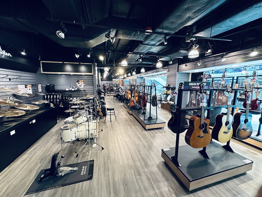 An interior view of Yamaha Music Store, showcasing a wide array of guitars, drums, and other musical instruments.