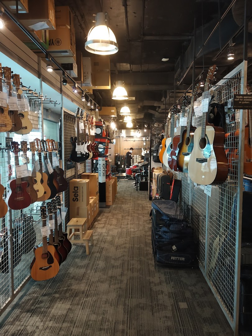 An interior view of Yamaha Music Store, showcasing a wide array of guitars, ukuleles, and other musical instruments.